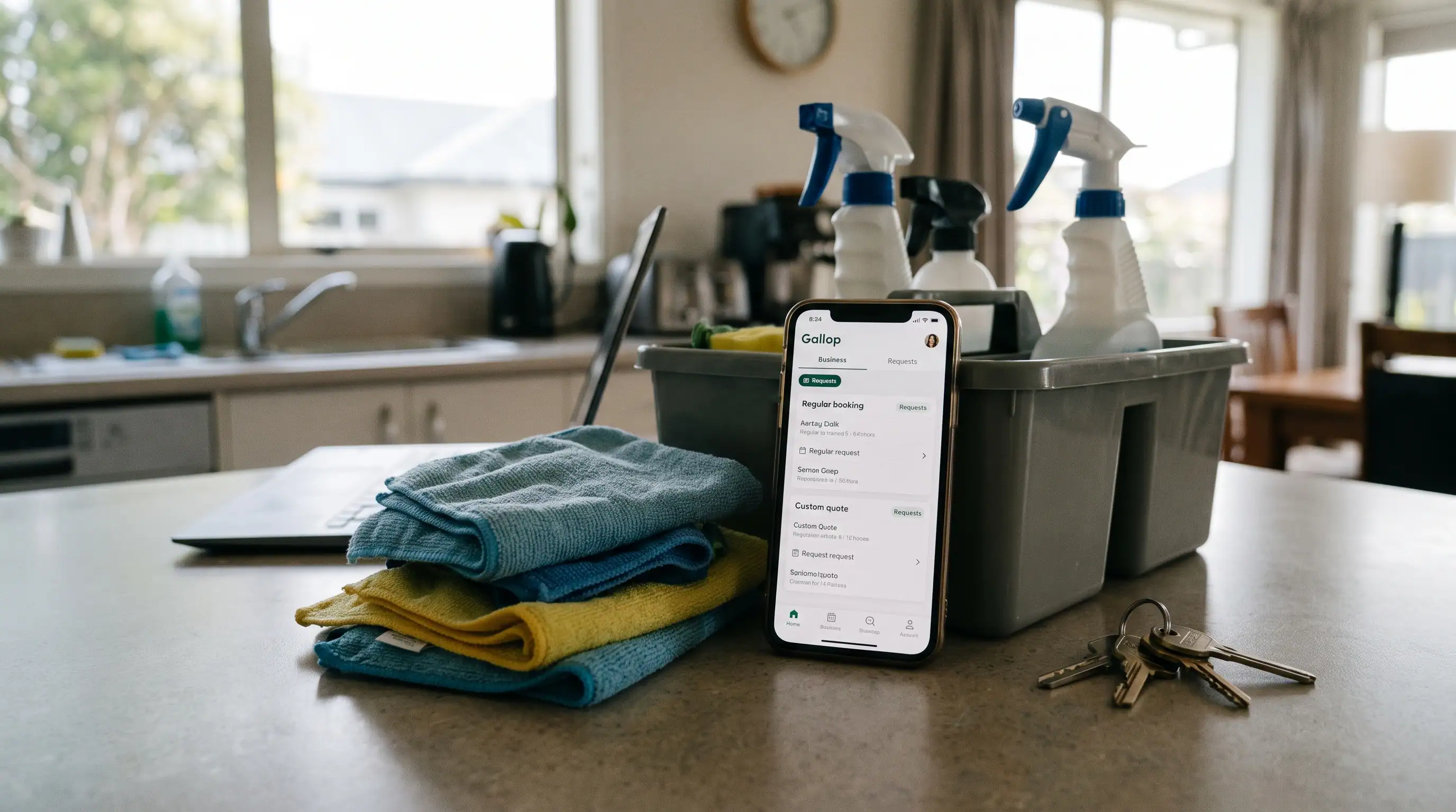 Cleaning supplies in a caddy beside a phone showing the Gallop business app on a kitchen counter, with options for regular bookings and custom quotes.